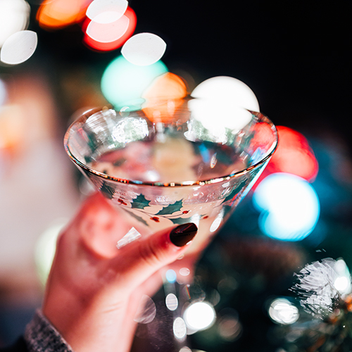 hand holding martini in holiday glass